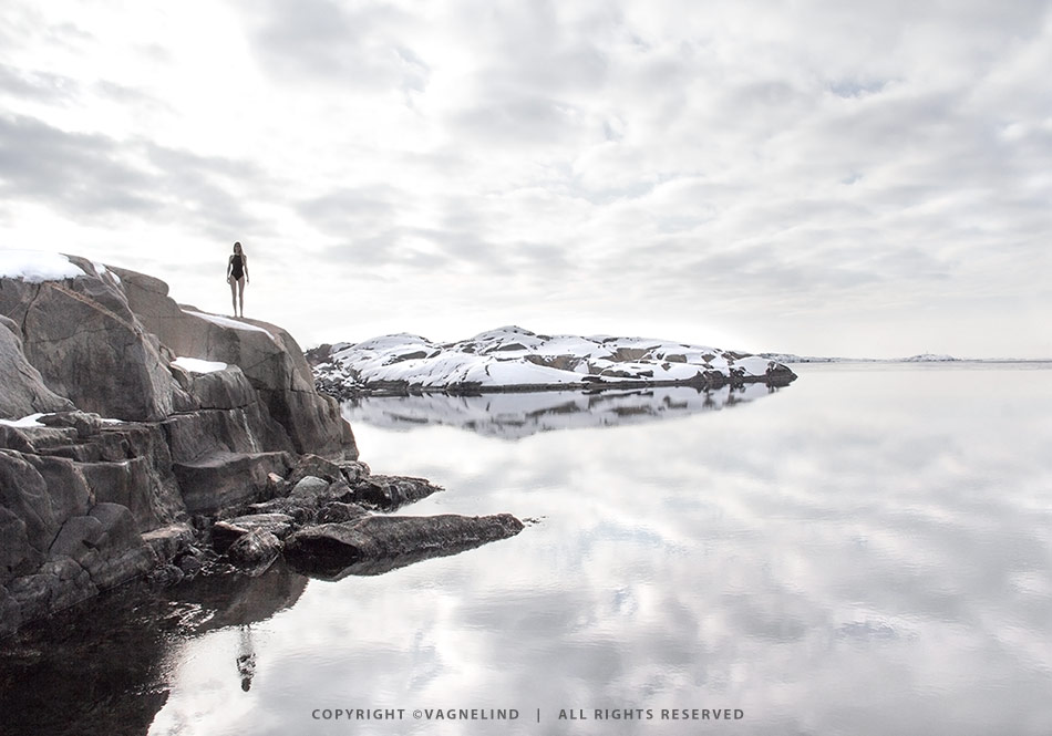 Cold water swimming in Sweden, photographed by Vagnelind for the book KALLA BAD, showing a woman entering icy water.