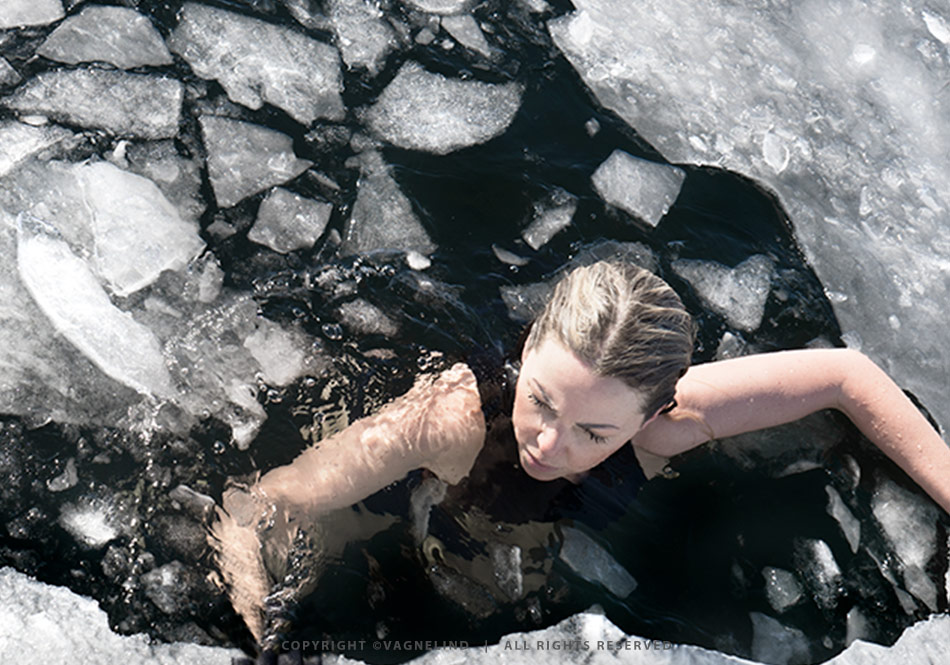 Cold water swimming in Sweden, photographed by Vagnelind for the book KALLA BAD, showing a woman entering icy water.